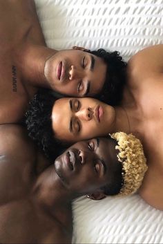 two men and a woman laying on top of each other with their heads close together