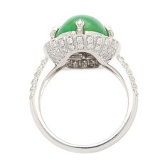 This is part of Chairish’s Fine Jewelry assortment.  Introducing a captivating 18K White Gold Ring, weighing 7.04 grams and adorned with a prong setting for timeless elegance. At the heart of this ring is a vibrant 7.29 carat cabochon-cut "A" grade Jadeite Jade, showcasing a rich green hue. Accentuating the Jade are 126 round-cut Diamonds, totaling 1.19 carats, delicately arranged to enhance the ring's overall brilliance.  Fixed with an intricate milgrain finish around the gemstones.   Item Deta Luxury Green Diamond Ring For Formal Occasions, Green Oval Dome Ring For Formal Occasions, Elegant Cabochon Emerald Ring For Formal Occasions, Elegant Domed Emerald Ring, Luxury Green Domed Ring, Timeless Green Diamond Round Ring, Luxury Oval Green Dome Ring, Elegant White Gold Cabochon Emerald Ring, Elegant White Gold Emerald Cabochon Ring