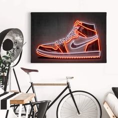 a neon nike shoe is displayed on the wall above a bicycle in a white room