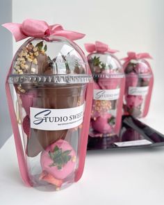 there is a glass jar filled with chocolates and strawberries in it's display case