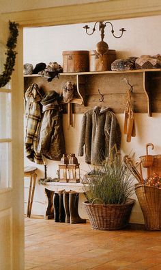 a room filled with lots of coats hanging on the wall next to a potted plant