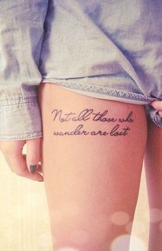 a woman's thigh with a tattoo that reads, not all those who wander are lost