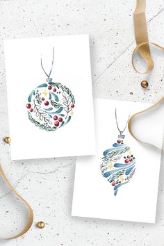 two cards with christmas ornaments on them next to a ribbon and some other items in the background