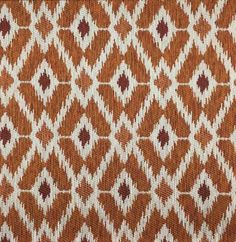 an orange and white pattern on fabric with a ruler in the foreground, next to it