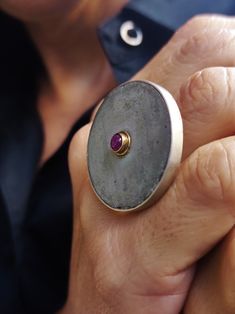 "Concrete disc ring 925 Sterling Silver for women. A handcrafted ring made with 925 Sterling Silver and adorned with one concrete round disc and adorned with one dainty red ruby tied with 14k solid Gold. A big statement ring for appearances to be discussed! Ruby is July's Birthstone! Rubies are often associated with wealth and prosperity. Many ancient crowns were decorated with rubies, because they represented good fortune and courage. The ruby's deep red color also has ties to love, passion, and raw emotion. In contact with skin, moisture and air, concrete becomes darker. DESCRIPTIONS and MEASUREMENTS: Material:Sterling silver, 14k  god. Surface: Concrete Gem :Ruby 4 mm Dimensions: Concrete  diameter 3,8cm 1,49(in)\" SEE MORE CONCRETE JEWELRY HERE: www.etsy.com/shop/ArtisJewels?ref=seller Wax Carving Jewelry, Concrete Ring, Big Statement Rings, July Birthstone Ring, Concrete Jewelry, Metalwork Jewelry, Art Jewelry Contemporary, Handcrafted Rings, Round Rings