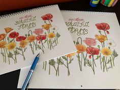 two notebooks with flowers drawn on them next to a pen and crayon markers