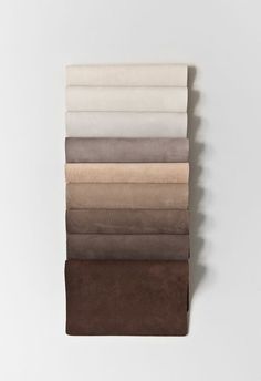 six different colors of fabric folded on top of each other, one in white and the other in brown