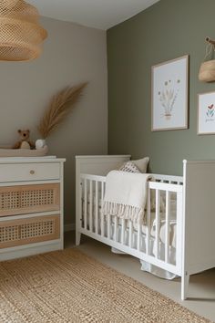 a baby's room with a crib, dresser and pictures on the wall