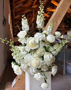 a white vase filled with lots of white flowers