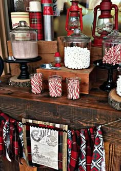 a table topped with lots of red and white candy canes on top of wooden boxes