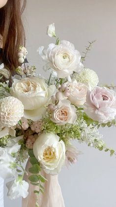 a woman holding a bouquet of white and pink flowers