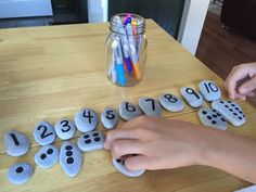 a child is playing with rocks that have numbers on them