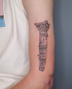 a man with a tattoo on his arm that has a tall building in the middle