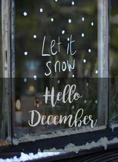 a window with the words let it snow and hello december written in white on it