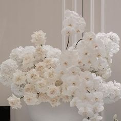 a white vase filled with lots of white flowers