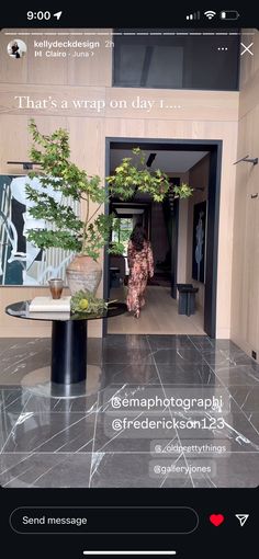 an image of a woman walking into a room with plants on the floor and in front of her