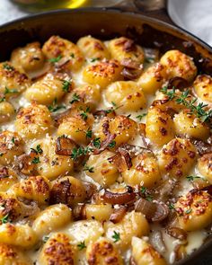 a skillet filled with cooked scallops covered in cheese