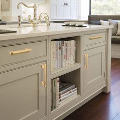 a kitchen island with bookshelves and cabinets in it