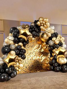 black and gold balloon arch with happy new year sign