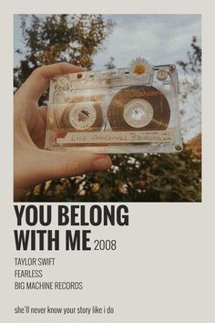 a person holding up a cassette with the words you belong with me