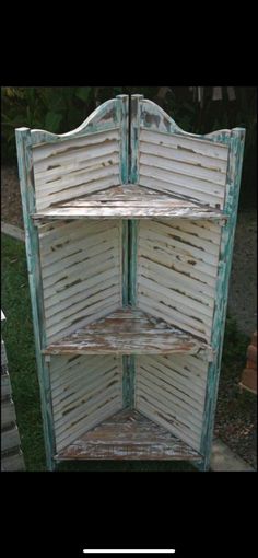 an old wooden shelf is painted white and has shutters on the sides, as well as wood slats