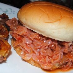 a sandwich with meat and onions on a plate