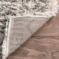 an area rug on top of a wooden floor next to a piece of wood that has been cut in half