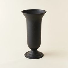 a black vase sitting on top of a white table