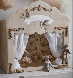 there is a doll house made out of wood and white fabric on top of a shelf