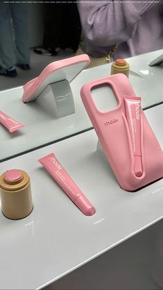 a pink phone case sitting on top of a counter next to other items and tools