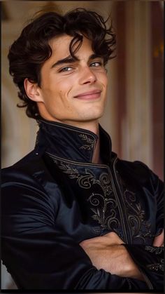 a young man with curly hair wearing a black jacket and smiling at the camera while standing in front of a wall