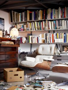 a living room filled with furniture and bookshelves full of different types of books