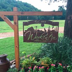 a wooden sign that says wake tea in front of some flowers and plants on the grass