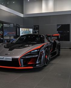 an orange and gray sports car in a showroom