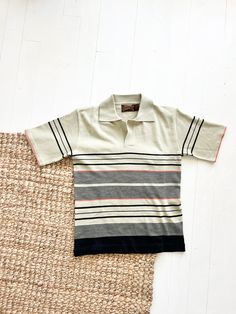 Vintage 1960s Knit striped polo Sundowner by Erika Strasberg gorgeous tan khaki coloring with black and red stripes excellent condition/some pilling 100 % acrylic made in Hong Kong listed as a size large Measurements Length: 25" Chest: 19" Sleeves: 9.5" Shoulder to Shoulder: 17.5" Measurements are taken flat Measurements: please allow a little extra room for comfortable fit and ease of movement These measurements are a guide. When in doubt, measure a garment that is comfortable and compare the m 50s Rockabilly, Khaki Color, Striped Shirt, Comfort Fit, Black And Red, Stripes, Tee Shirts, Mens Outfits, Knitting