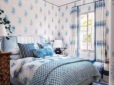 a bedroom with blue and white bedding and curtains