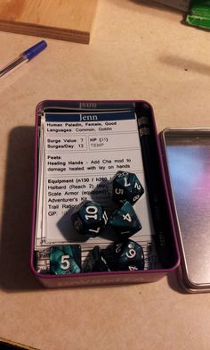 two tins filled with dice sitting on top of a table