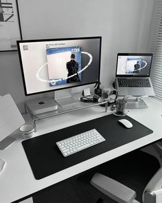 two computer monitors sitting on top of a white desk