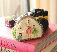 a purse sitting on top of a stack of books next to a camera and book