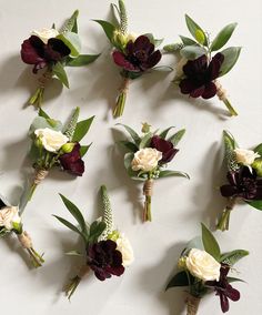 a bunch of flowers that are sitting on a table together with leaves and stems around them