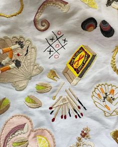 an assortment of embroidered objects on a white cloth