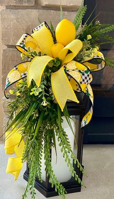 a lantern decorated with yellow flowers and greenery