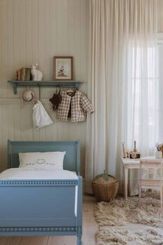 a child's bedroom with white walls and blue furniture