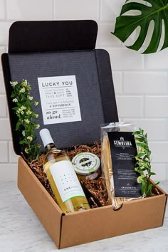 an open gift box containing two bottles of wine, soap and other personal care items