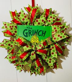 a green and red wreath with the grin on it