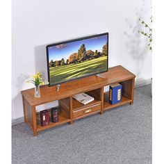 a flat screen tv sitting on top of a wooden shelf