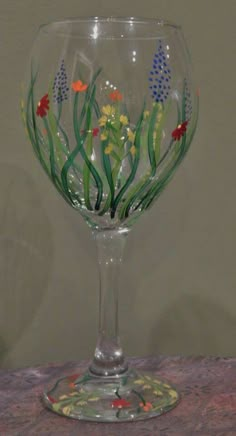 a wine glass with flowers painted on it