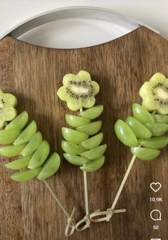 some kiwi fruit are arranged on sticks to look like they have been cut in half