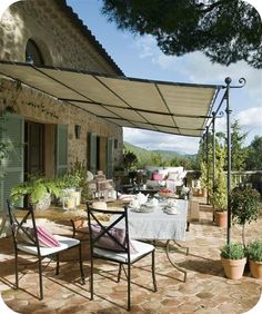 an outdoor dining area with patio furniture and potted plants