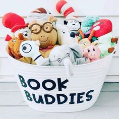 a bucket filled with stuffed animals sitting on top of a wooden floor next to a white wall